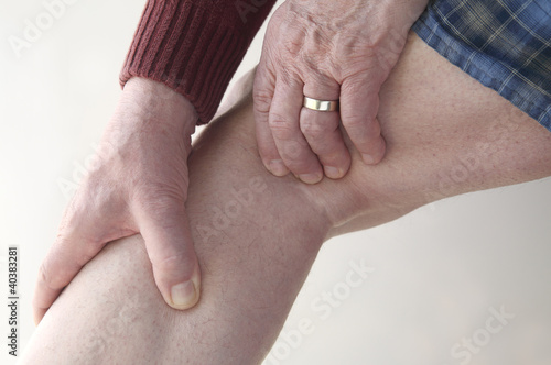 Photo: man checks pain in his leg man checks pain in his leg