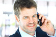 Smiling man using an office phone Smiling man using an office phone