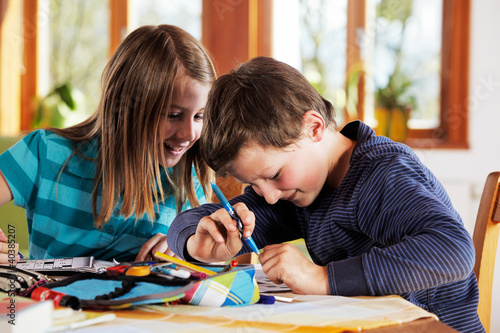 Foto: boy and girl squabbling while doing homework boy and girl squabbling while doing homework