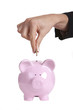 Photo: Woman putting a coin in a piggy bank Woman putting a coin in a piggy bank