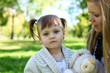 Little girl playing with mother in summer park
