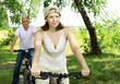Photo: Young couple on the bikes in the park Young couple on the bikes in the park