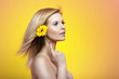 Sexy young blond woman holding yellow gerber