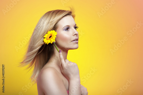 Foto: Sexy young blond woman holding yellow gerber Sexy young blond woman holding yellow gerber