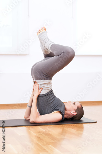 Photo: Woman doing stretching yoga exercise at sport gym Woman doing stretching yoga exercise at sport gym