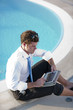 Photo: Young businessman working near the pool Young businessman working near the pool