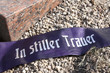 Trauerschleife auf einem Friedhof - "In stiller Trauer"