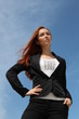 Pretty redhead young woman posing, with sky background