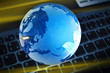Foto: Blau beleuchteter Glasglobus auf Tastatur Blau beleuchteter Glasglobus auf Tastatur