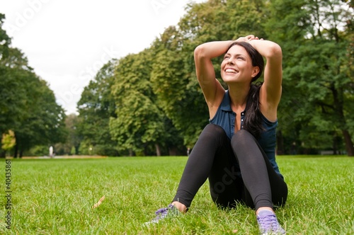 Foto: Relax - sportswoman sitting in grass Relax - sportswoman sitting in grass