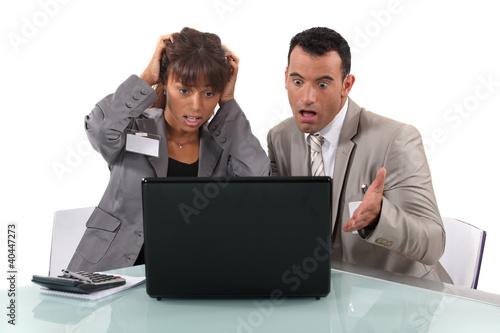 Photo: Two business people shocked by laptop Two business people shocked by laptop