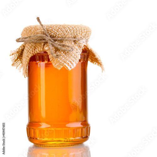 Photo: Sweet honey in jar isolated on white Sweet honey in jar isolated on white