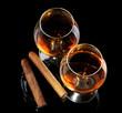 two glasses of brandy and cigars on black background