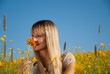 junge Frau mit Blume in der Wiese