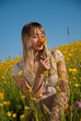 junge Frau mit Blume in der Wiese