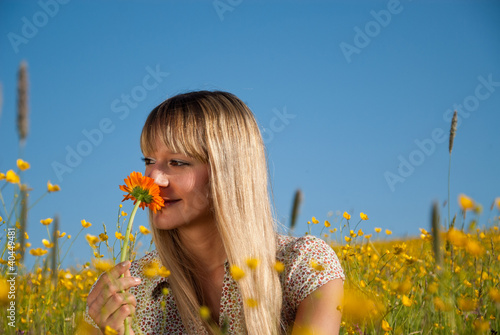 Photo: junge Frau mit Blume in der Wiese junge Frau mit Blume in der Wiese