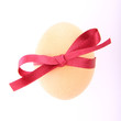 Chicken egg decorated with a red ribbon Chicken egg decorated with a red ribbon