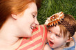 Smiling Mother And Daughter Laying In Tall Grass