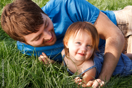 Photo: Happy Father And Daughter Laying In Grass Happy Father And Daughter Laying In Grass