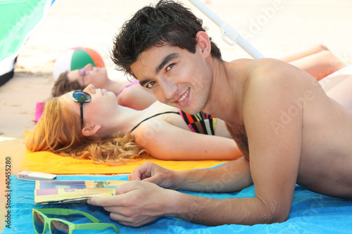 Photo: Three fiends laid on a beach Three fiends laid on a beach