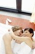 A couple laughing while lying on the bed together.