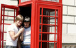 Foto: A couple listening to a phone call together in the telephone booth. A couple listening to a phone call together in the telephone booth.