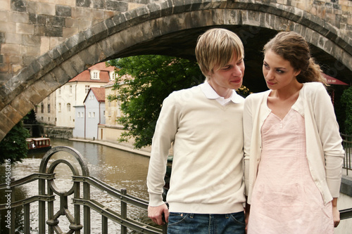 Photo: A couple standing near the bridge. A couple standing near the bridge.