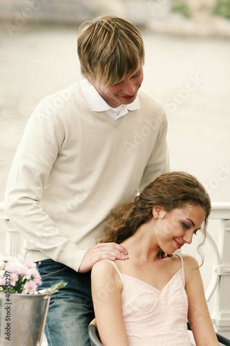 Foto: A guy giving his girlfriend a shoulder massage. A guy giving his girlfriend a shoulder massage.