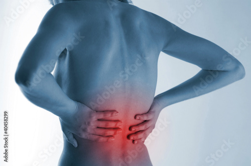 Photo: Back shot of a naked woman touching her aching back. Back shot of a naked woman touching her aching back.