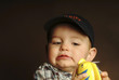 A boy with cap playing with his toy fish.