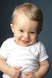 A young boy laughing cheekily.
