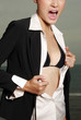 A lady unbuttoning her shirt exposing her bra.