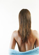 Back shot of a lady letting her bathrobe slipping down from her body.