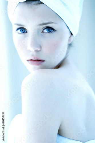 Photo: Side shot of a woman with her hair and body wrapped up in towel looking at the camera. Side shot of a woman with her hair and body wrapped up in towel looking at the camera.