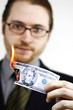 A bespectacled man in business suit burning a banknote.