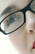 Close-up picture of a lady's face with black rimmed spectacles.