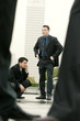 An angry looking man and his asian colleague waiting anxiously for their client