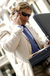 Photo: a man with sunglass searching for documents from his briefcase while talking on the handphone. a man with sunglass searching for documents from his briefcase while talking on the handphone.
