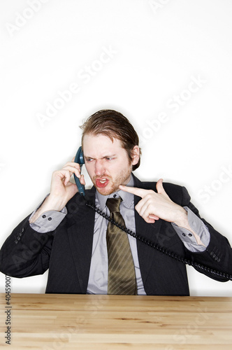 Photo: a man in business suit talking angrily on the phone. a man in business suit talking angrily on the phone.