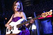 Young guitar player performing in night club