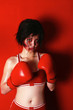 Foto: A swollen faced lady in boxing suit and gloves looking at the camera. A swollen faced lady in boxing suit and gloves looking at the camera.