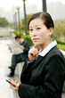 Foto: A woman using palmtop and a man reading newspaper. A woman using palmtop and a man reading newspaper.