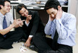 A group of men playing cards in the office. 