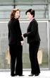 Two women carrying paper bags. 