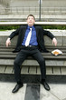 Photo: A man resting on a bench with his lunch by the side. A man resting on a bench with his lunch by the side.