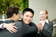 Two men hugging each other while a woman clapping her hands. 