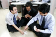 A group of men playing cards in the office. 