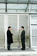 Two men in business suits talking. 