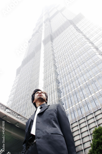 Photo: Man in business suit standing in front of the building. Man in business suit standing in front of the building.