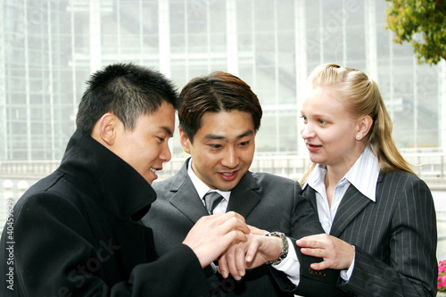 Photo: A group of business people looking at the time. A group of business people looking at the time.